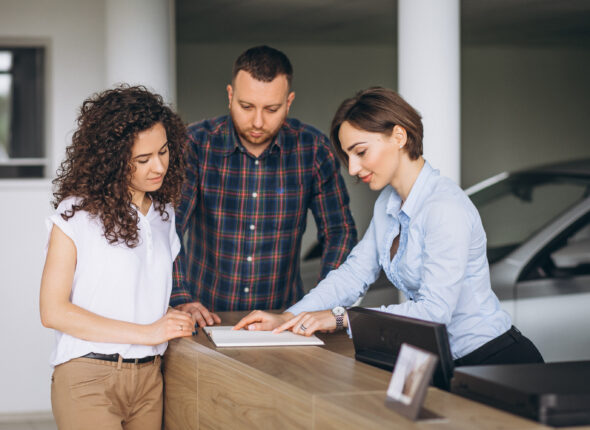 Young couple byuing a car in a car showroom